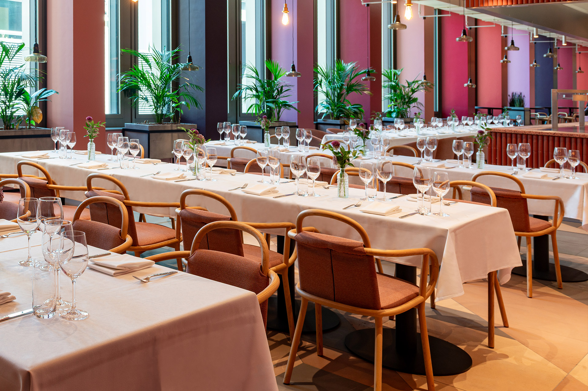 Stilvoll eingerichteter Dining-Bereich mit langen Tafeln und hochwertiger Tischdekoration.